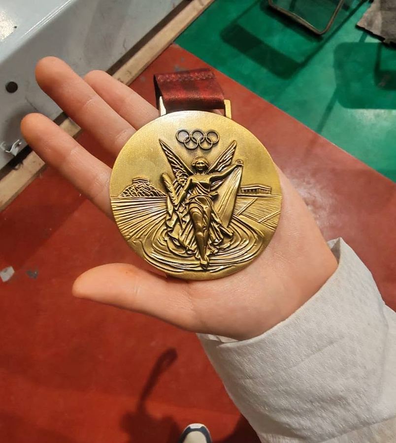 Medalla dorada en la palma de la mano de un competidor